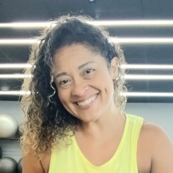 Naty Gomes, personal trainer no Guarujá, sorrindo em ambiente de treino